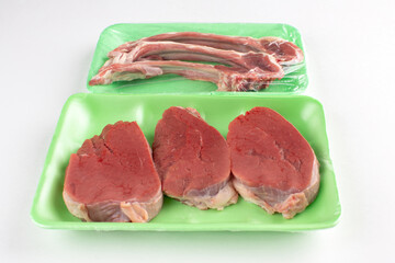 Beefsteak and lamb ribs in green plastic container