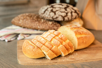 Sliced bread on the table on a background of various breads.