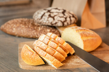 Sliced bread on the table on a background of various breads.