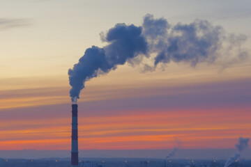 Lonely chimney with smoke and carbon dioxide emissions from fuel combustion.