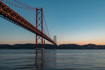 Fototapeta na wymiar Panorama view over the 25 de Abril Bridge. The bridge is connecting the city of Lisbon to the municipality of Almada on the left bank of the Tejo river, Lisbon