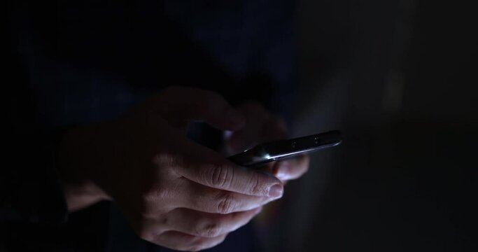 4K Video close up hand touch and text on mobile phone screen in the dark tone. Concept for mobile technology and lifestyle.