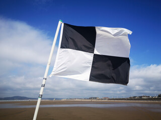 A black and white checkered flag indicates that surfing is allowed but swimming is not - UK