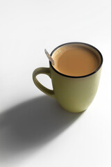 On a white background there is one mug, in it hot coffee with milk