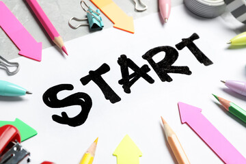 Sheet of paper with word Start and stationery on table, closeup