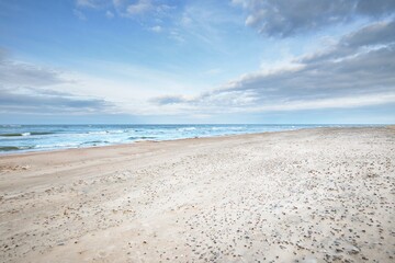 Panoramic view of the Baltic sea from a sandy shore (sand dunes). Dramatic sky with glowing clouds,...