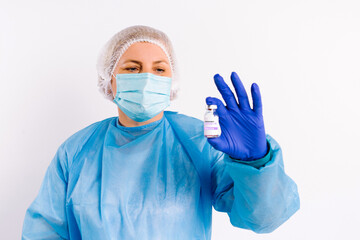 Fototapeta na wymiar A doctor in protective medical equipment and latex disposable gloves holds an ampoule with a vaccine and shows it to the camera. White background. Fighting covid 19.