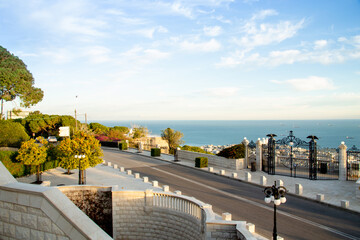 Haifa, Israel, January 23, 2021: sunrise over decoratively decorated metal gates at the upper entrance to the Bahai Garden, that located on the Louis Promenade, in Haifa city, space for text