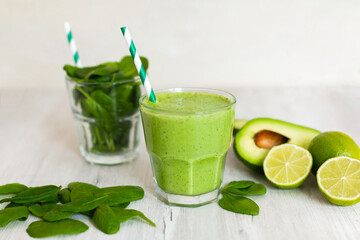 Healthy green smoothie with spinach, avocado and lime, on wooden table 