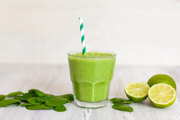 Healthy green smoothie with spinach, avocado and lime, on wooden table 