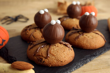 Delicious cookies decorated as monsters on wooden table, closeup. Halloween treat