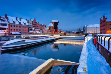 Fototapeta na wymiar Medieval port crane in Gdansk at Motlawa river in snowy winter, Poland