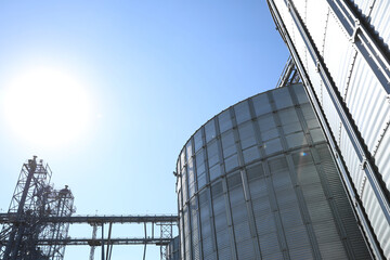 Modern granaries for storing cereal grains against blue sky, low angle view