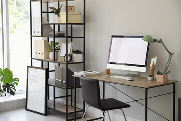 Comfortable office chair near desk with modern computer indoors