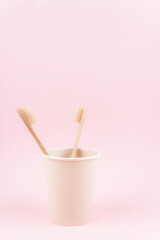 Two eco friendly bamboo toothbrushes in the paper cup.