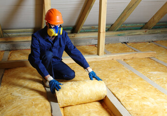 Worker in protective respirator insulating glass wool insulation