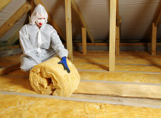 Worker in protective respirator insulating glass wool insulation