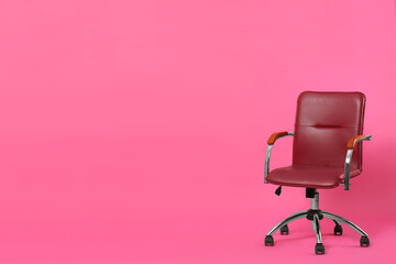 Comfortable office chair on pink background, space for text