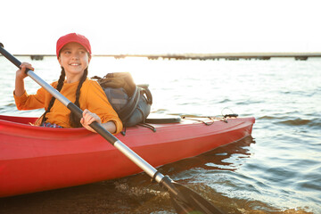 Happy girl kayaking on river. Summer camp activity