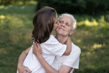 Affectionate granddaughter and grandmother are hugging. Happy together