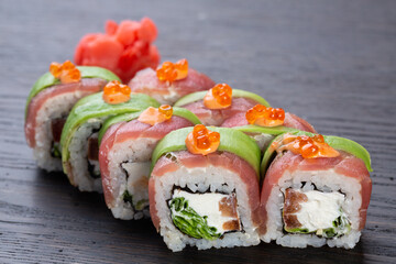 traditional Japanese sushi with salmon, avocado and soft cheese, garnished with red caviar. Japanese kitchen. Japanese restaurant.