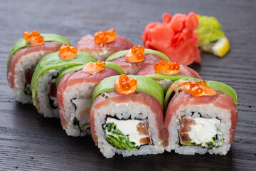 traditional Japanese sushi with salmon, avocado and soft cheese, garnished with red caviar. Japanese kitchen. Japanese restaurant.