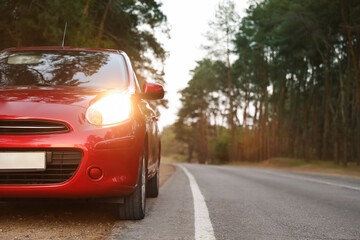 Red car parked near forest. Road trip