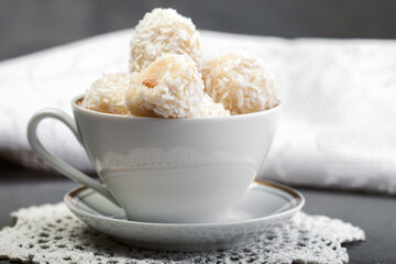 Homemade white chocolate and coconut sweets on a plate on the table. Snowball candy truffles. Selective focus