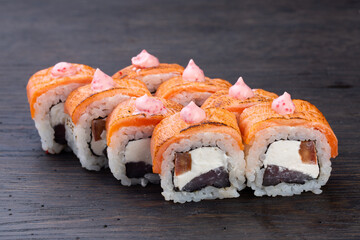 traditional Japanese sushi with salmon, soft cheese, avocado and red caviar, garnished with creamy sauce. Japanese kitchen. Japanese restaurant.