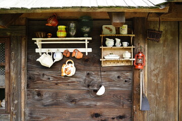 stare naczynia wiszące na ścianie starego drewnianego domu w polskiej wsi - obrazy, fototapety, plakaty