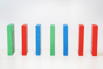 Colored dominoes stand in a row on a white background. Multicolored domino