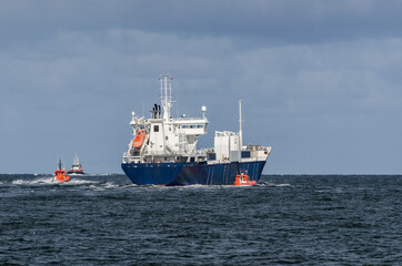 Naklejka premium MERCHANT VESSEL - The freighter follows waterway