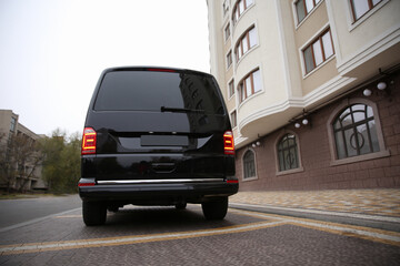 Black delivery van parked on street near building © New Africa