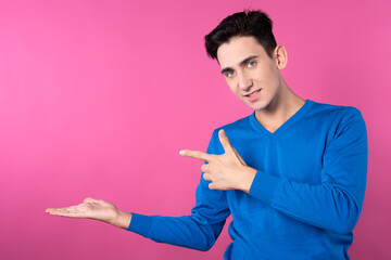 A young man gestures with his hands. Pink background. Consent and denial. Good and bad.