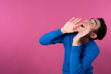 A young man gestures with his hands. Pink background. Consent and denial. Good and bad.