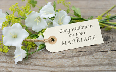 Greeting card with white bell flowers and english text  congratulations on your marriage