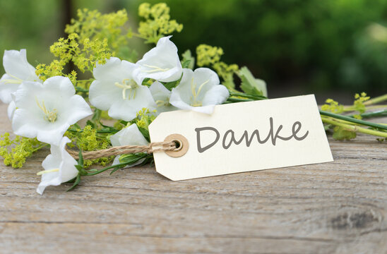Greeting card with white bell flowers and german text thanks