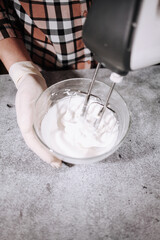 Fototapeta premium Cooking cream for cake in a glass bowl and mixer.