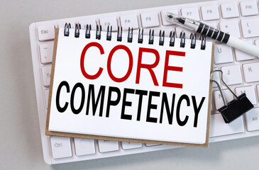 core competency, text on white notepad paper on gray background