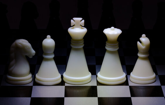 An image of black and white chess pieces on a chessboard
