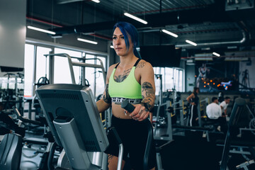 Obraz na płótnie Canvas tattooed woman workout in gym