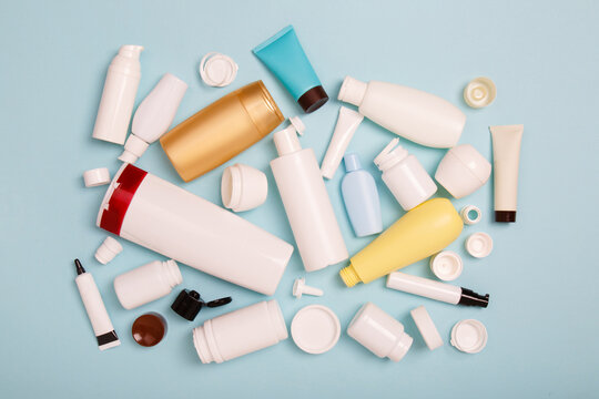 separate collection of sorted HDPE bottles from cosmetics for recycling. High-Density Polyethylene recyclable cosmetics package on blue background. Plastic garbage. Save the planet