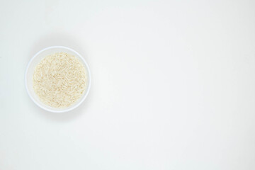 Bowl of long grain white rice, isolated on white background. Copy space.