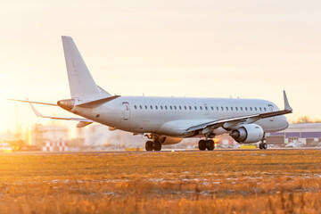 Fototapeta na wymiar Airplane plane is accelerating along the runway against the background of dusk sky.