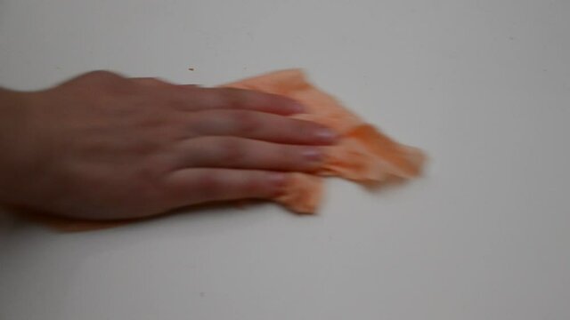 hand with wet wipe cleaning table