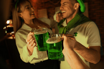 People with beer celebrating St Patrick's day in pub, focus on hands