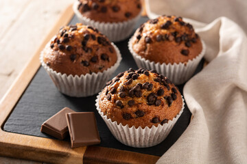 Just baked chocolate muffins on rustic wooden table - obrazy, fototapety, plakaty