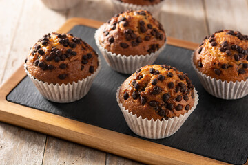 Just baked chocolate muffins on rustic wooden table