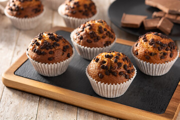 Just baked chocolate muffins on rustic wooden table