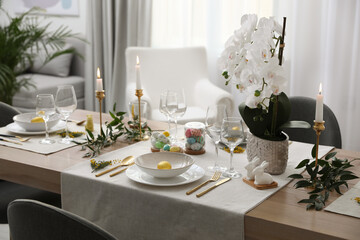 Beautiful Easter table setting with white orchid flowers indoors